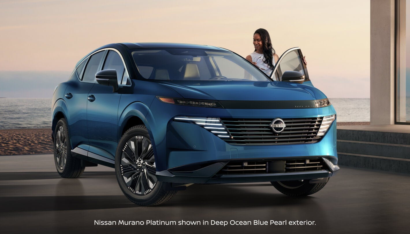 Front three quarter view of a 2027 Nissan Murano Platinum in Ocean Blue Pearl with a woman opening the door.